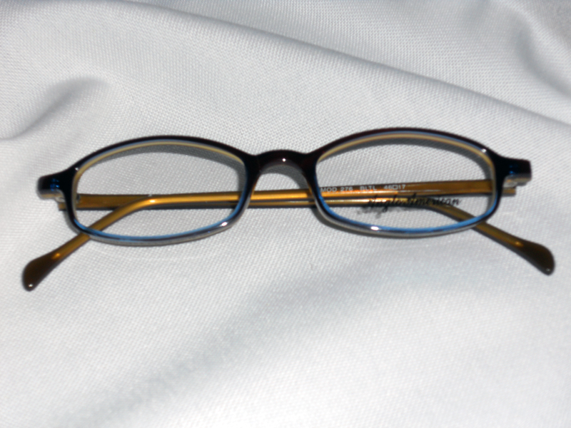 A pair of glasses sitting on top of a white sheet.